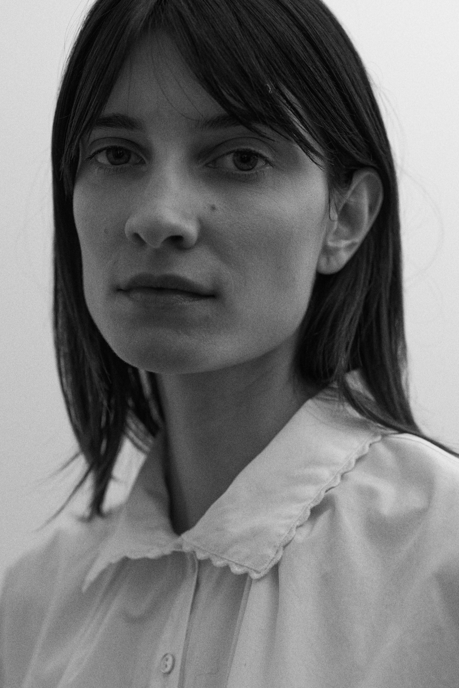 Black and white portrait of a woman wearing a white shirt with a lace collar.