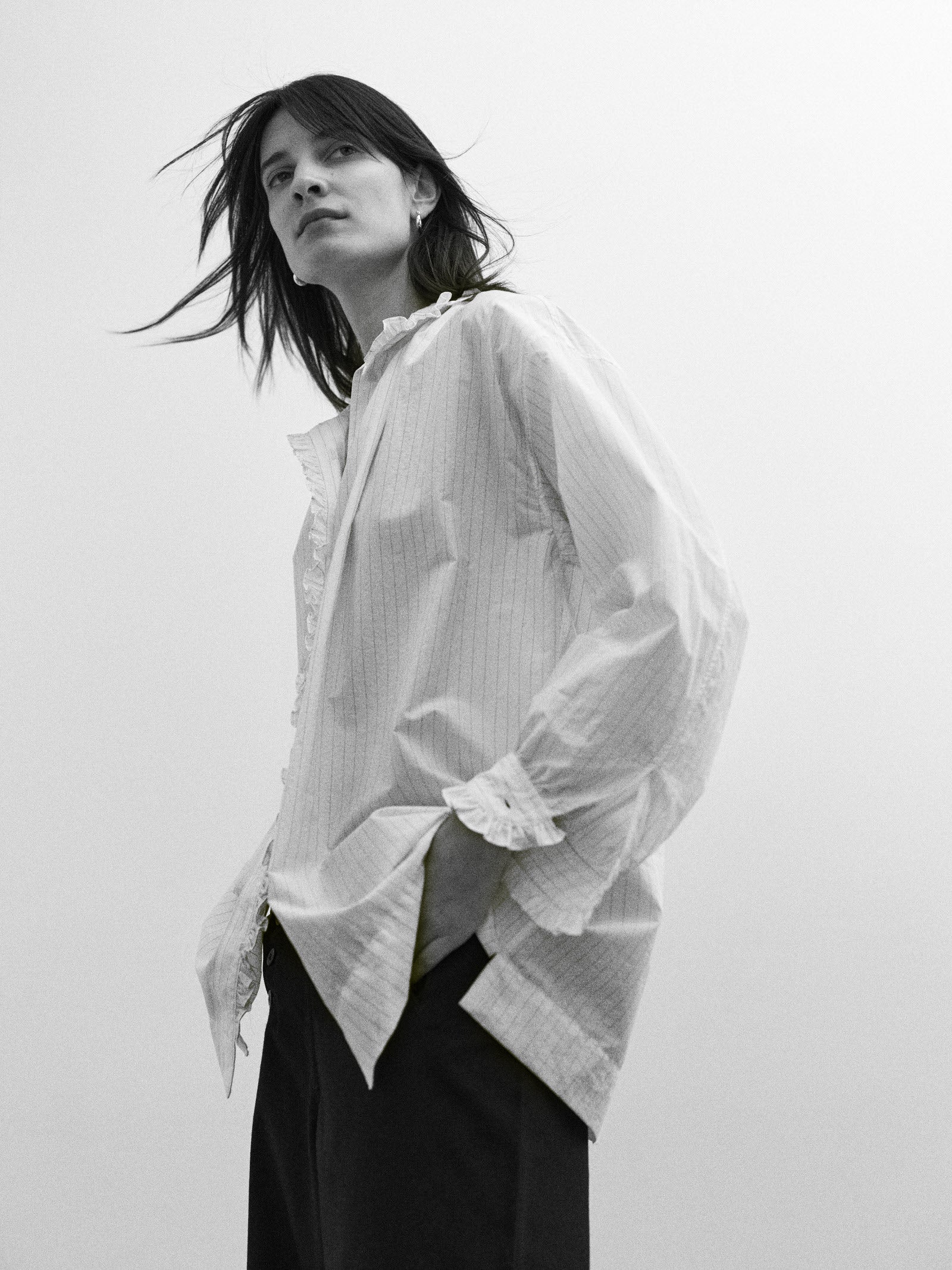 Woman wearing a thin striped white shirt with a plain background